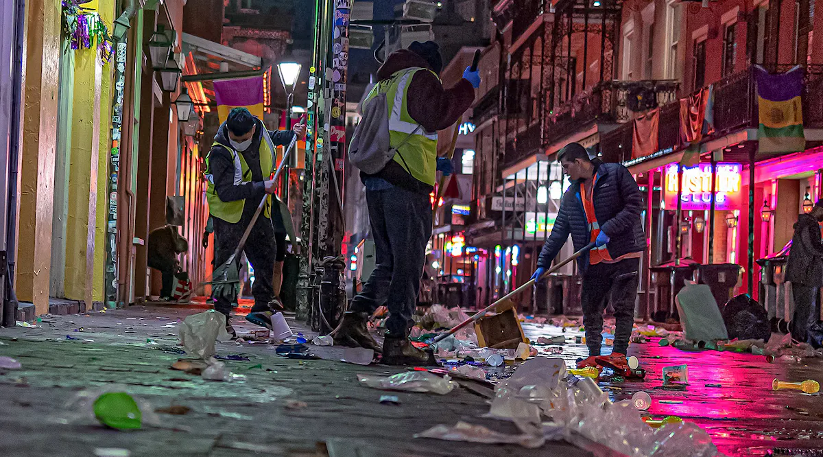 KBNS crew members clean the streets after Mardi Gras