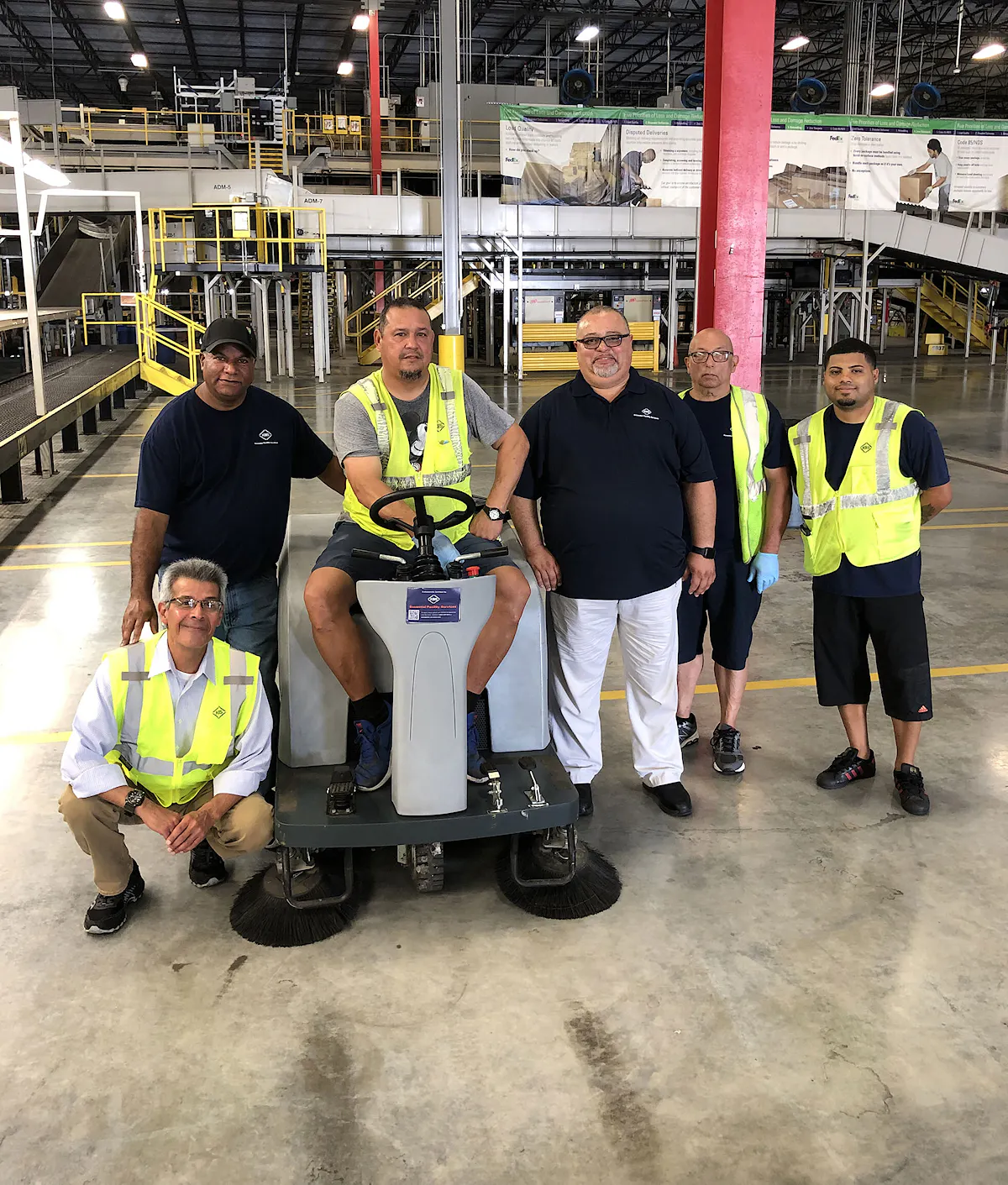 KBS team huddles in a warehouse